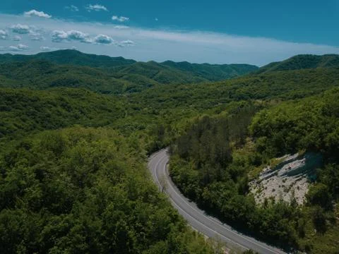 Mountain winding zig zag road. Top aerial view: cars driving on road from above. Stock Photos