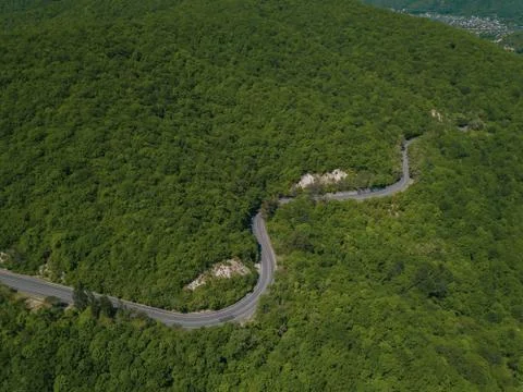 Mountain winding zig zag road. Top aerial view: cars driving on road from above. Fotos Stock