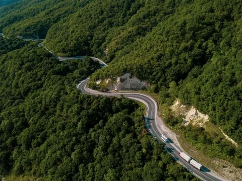 Mountain winding zig zag road. Top aerial view: cars driving on road from above. Fotos Stock