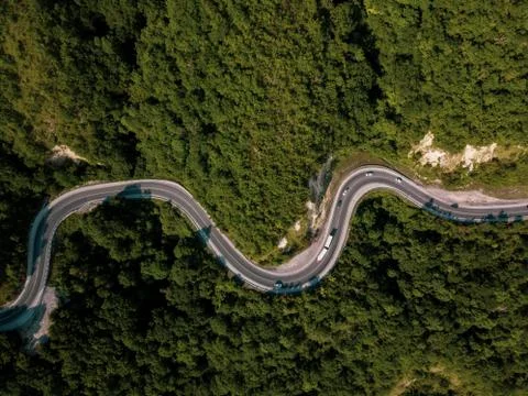 Mountain winding zig zag road. Top aerial view: cars driving on road from above. Fotos Stock