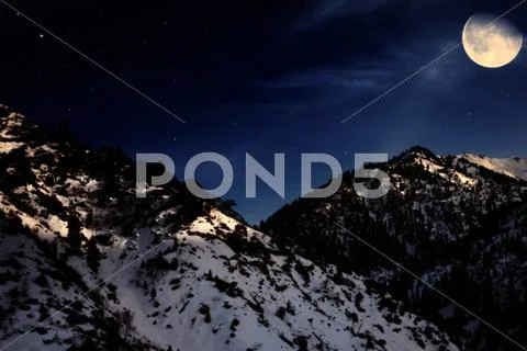 Mountain winter landscape with yellow moon Stock Photos