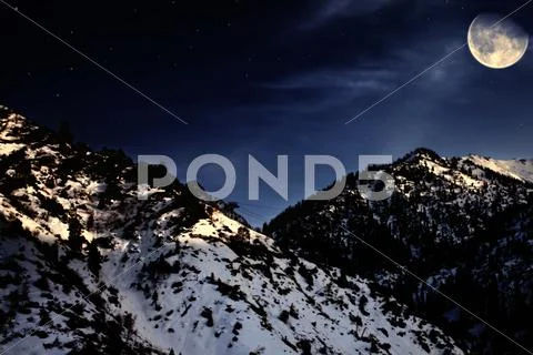 Mountain winter landscape with yellow moon Stock Photos