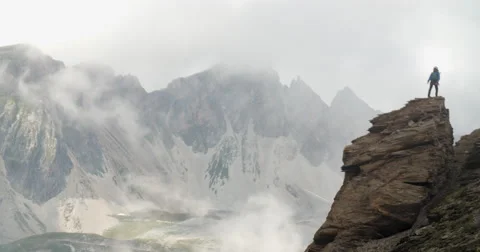 Mountaineer Climbing Rock Stack in Stormy and Windy Conditions. Stock-Footage 68942961