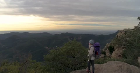Mountaineer looking at horizon with cap, backpack and face mask pandemic in peak 스톡 동영상 147955495