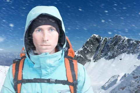 Mountaineer man looking at the camera, in the background high mountains. Close Stock Photos