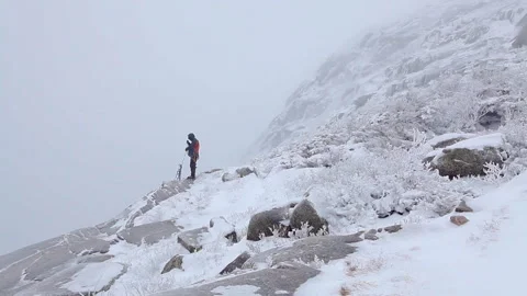Mountaineer preparing climbing rope in a winter snow storm Stock Footage 335092412
