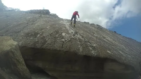Mountaineer rappel down a long steep rocky mountain Stock Footage 143449378