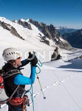 Mountaineer taking picture with a camera in the mountains. Stock Photos