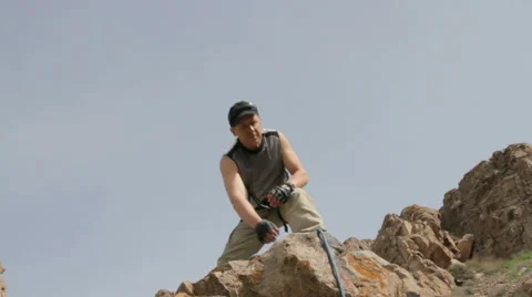 Mountaineer throws down a safety rope Stock Footage 62389414