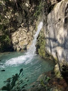 A mountainous and fast river, falls from a high cliff forming a waterfall. Stock Photos