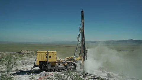 In a mountainous area, a drilling rig makes a hole in a rocky rock, preparing a Vidéo 153800495