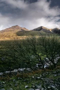 Mountainous landscape with dramatic clouds and early evening light Stock Photos