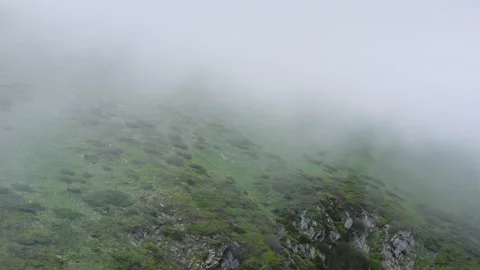 The mountainous landscape is hidden behind thunderclouds. Flying through the Stock Footage 135321879