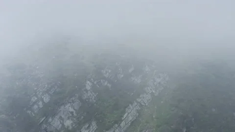 The mountainous landscape is hidden behind thunderclouds. Flying through the Stock Footage 135322166