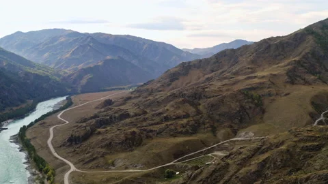 Mountainous landscape with river, road and small village of several houses Stock Footage 194379488