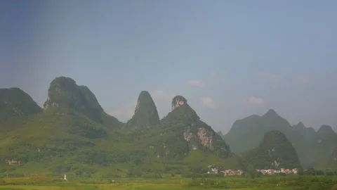 The mountainous landscape with sugar loaves scrolls from the train, in China Stock Footage 232131912