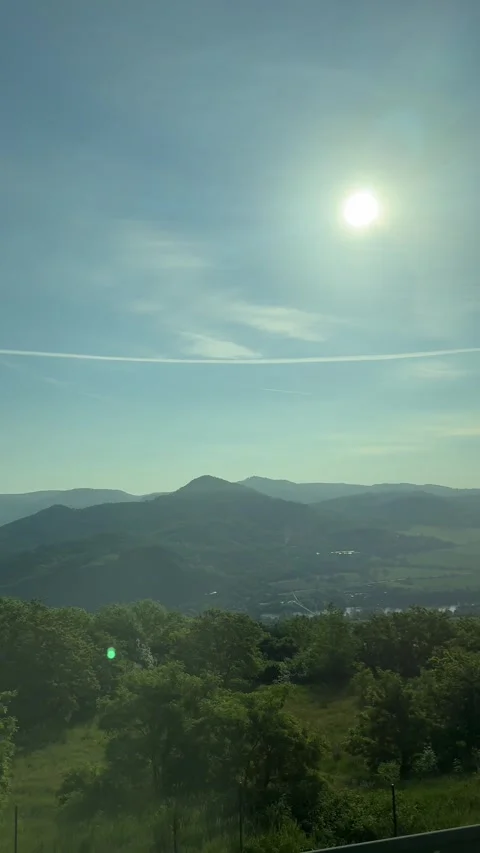 Mountainous landscape view, distant green hill, clear summer sky, radiant sun, Stock Footage 338126371