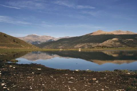 Mountainous reflection under a blue sky Stock Photos