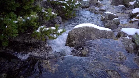 Mountainous river running down among snowy rocks and stones in early spring Видео 121395659