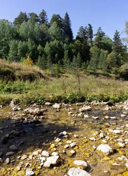 Mountainous terrain and a drying stream, a sunny autumn day, walking in the b Stock Photos