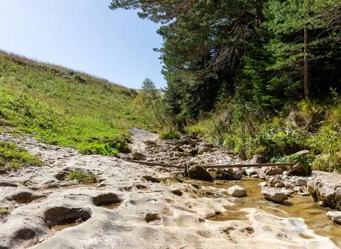 Mountainous terrain and a drying stream, a sunny autumn day, walking in the b Stock Photos