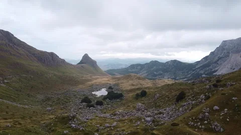 Mountainous valley showcasing small pond and rocky slopes in Durmitor Video stock 342774838