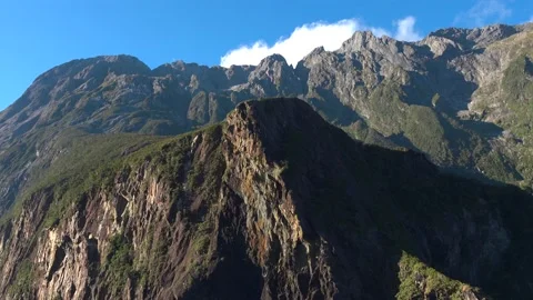 Mountains and cliffs in the sun and blue sky in New Zealand Milford Sound Stock Footage 132062799