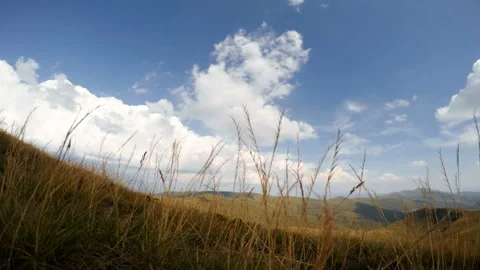 Mountains and Clouds on the Background of Grass. Time Lapse 4K Stock Footage 106458475