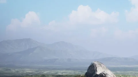 Mountains and clouds in the distance with a large rock in the foreground Stock Footage 340213771
