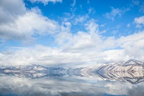 Mountains and Clouds reflected in the shallow water of Lake Shikotsu on the i Stock Photos