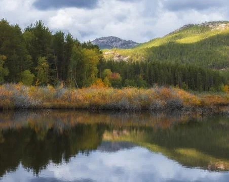 Mountains and forest reflected in the lake in autumn 스톡 사진