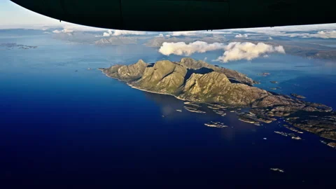 Mountains and the ocean seen below the engine of an airplane Stock Footage 268422485