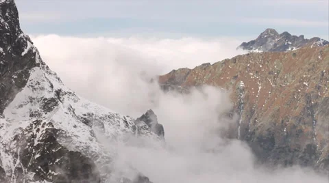 Mountains and thick clouds moving among sharp, rocky peaks Stock-Footage 39494609