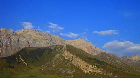 Mountains and valleys time lapse of puffy white clouds, blue skies and cloud sha Stock Footage 55876215
