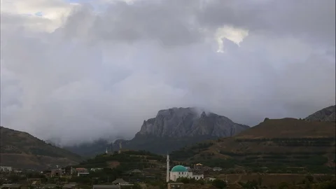 Mountains in the background of gray clouds. Dark clouds envelop the tops of the Stock Footage 97256958