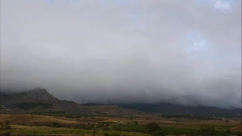 Mountains in the background of gray clouds. Dark clouds envelop the tops of the Stock Footage 97465071