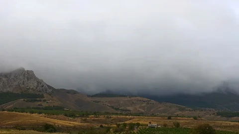 Mountains in the background of gray clouds. Dark clouds envelop the tops of the Stock Footage 99061735
