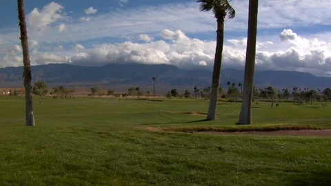 Mountains behind large grass golf course Stock Footage 125344598