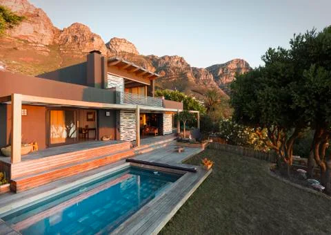 Mountains behind luxury home showcase exterior house with swimming pool Stock Photos