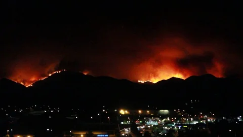 The mountains burn behind the city Stock Footage 109207229