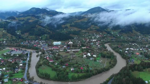 Mountains in clouds above the river and village Stock Footage 157734853