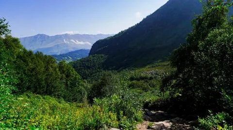 Mountains with clouds, a path and trees 스톡 사진