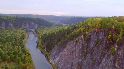 Mountains covered with dense forest and a river with blue water flowing through Stock Footage 155072754