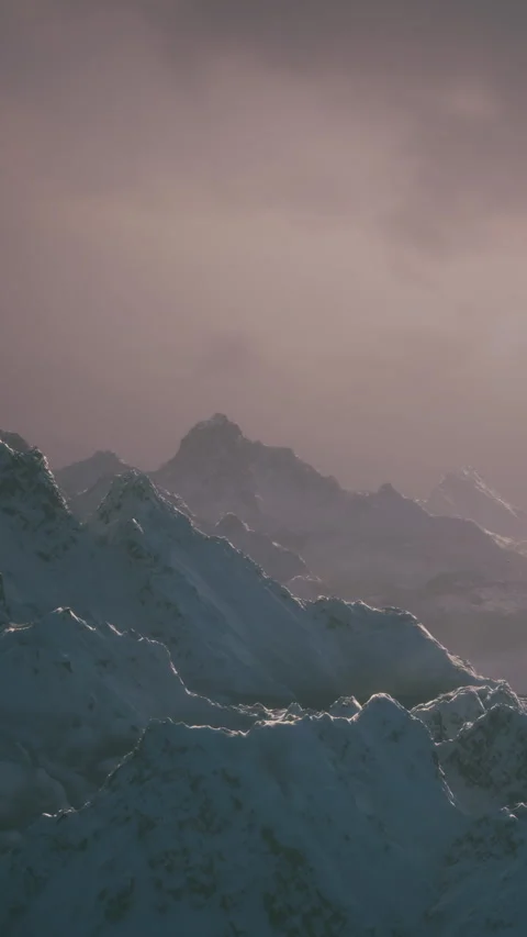 Mountains covered in snow against a cloudy sky at dusk in a cold place Video stock 339039217