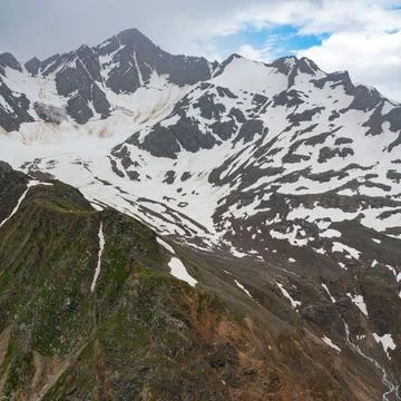 Mountains covered in snow with clouds overhead Stock Photos