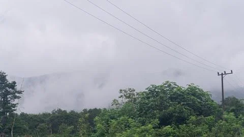 Mountains with greenery partially covered by clouds Stock Photos