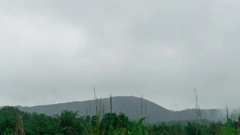 Mountains with greenery partially covered by clouds Stock Photos
