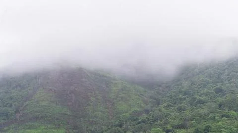 Mountains with greenery partially covered by clouds Stock Photos