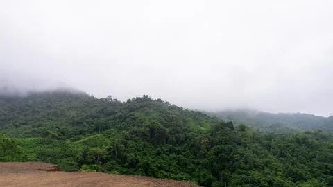 Mountains with greenery partially covered by clouds Stock Photos