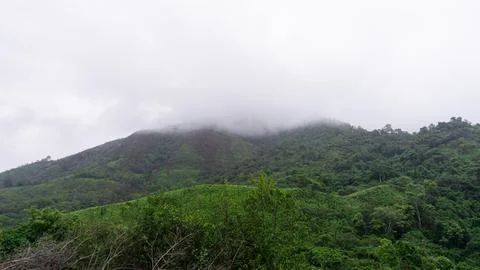 Mountains with greenery partially covered by clouds Stock Photos